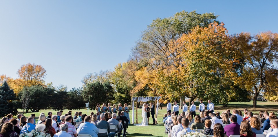 Guests watch the bride and groom get married outdoors