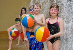 Children playing with beach balls under a waterfall